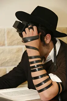 Orthodox Jew reading a prayer book and wearing phylactery Orthodox Jew reading a prayer book and wearing phylactery