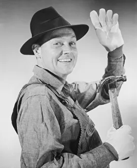 Portrait of carpenter waving and holding hammer Portrait of carpenter waving and holding hammer