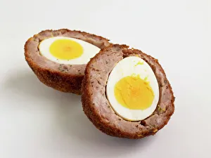 Scotch egg, sliced in two showing hard-boiled egg and sausage meat in breadcrumbs Scotch egg, sliced in two showing hard-boiled egg and sausage meat in breadcrumbs