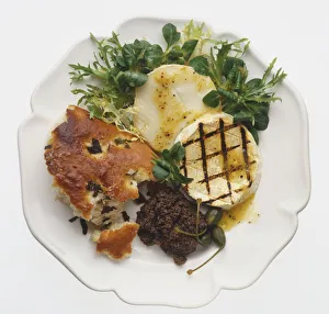 Seared goats cheese and Tapenade, served with bread and salad, view from above Seared goats cheese and Tapenade, served with bread and salad, view from above