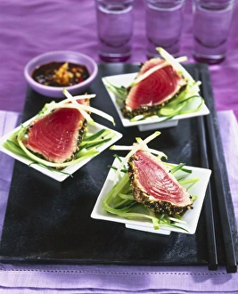 Seared sesame tuna with sweet soy and chilli dressing served on three bowls Seared sesame tuna with sweet soy and chilli dressing served on three bowls
