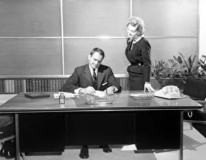 Secretary giving businessman papers to sign Secretary giving businessman papers to sign