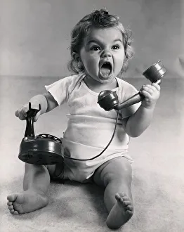 Vintage photo of infant screaming with phone Vintage photo of infant screaming with phone