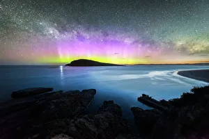 Colourful display of the Aurora Australis over an island in the ocean at Blue Hour Colourful display of the Aurora Australis over an island in the ocean at Blue Hour