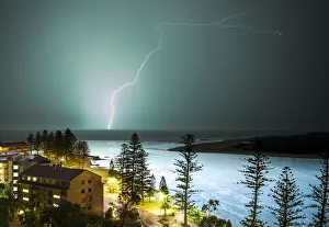A lightning strike hits the surface of the water in the distance A lightning strike hits the surface of the water in the distance