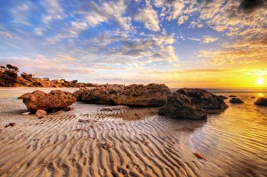 Sunset with Big Rocks and Sand Patterns at the Beach Sunset with Big Rocks and Sand Patterns at the Beach