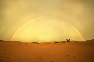 4X4 Vehicle on a Barren Desert Landscape Under a Rainbow 4X4 Vehicle on a Barren Desert Landscape Under a Rainbow