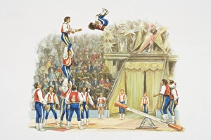 Acrobats performing in circus ring, jumping on springboard to form human pyramid Acrobats performing in circus ring, jumping on springboard to form human pyramid