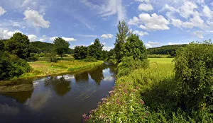 Altmuhlt river flows between green fields and trees, cloudy sky, Altmuhl Valley Nature Park, Obereichstatt, Bavaria Altmuhlt river flows between green fields and trees, cloudy sky, Altmuhl Valley Nature Park, Obereichstatt, Bavaria