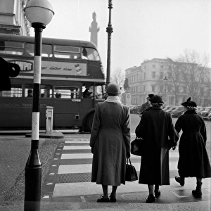 Belisha Beacon; Three ladies waiting to cross the road at a zebra crossing in London Belisha Beacon; Three ladies waiting to cross the road at a zebra crossing in London
