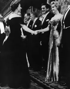 Prints of (Original Caption). Queen Elizabeth II of England offers a gloved hand to Hollywood glamour girl Marilyn Monroe Miller during the Queen's visit with celebrities at the Royal Film Performance Related Prints: Marilyn Monroe Meets Queen Elizabeth II Print