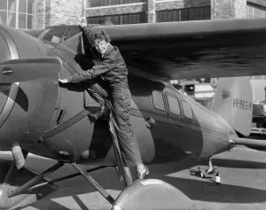 Prints of (Original Caption). Amelia Earhart, (1898-1937), first woman to cross the Atlantic Ocean in an airplane. She is shown climbing into the cockpit. Undated photograph Pioneer Prints: Amelia Earhart Climbing into Airplane Print (1930s)