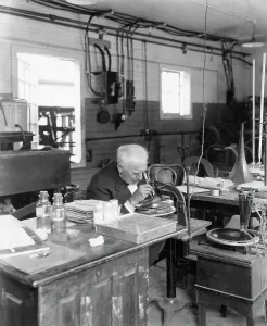 Thomas Edison Laboratory Prints: Thomas Edison Looking Through Microscope