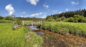 Bridge over the Morsbach stream with green meadows, Altmuhltal Nature Park, Bavaria, Germany Bridge over the Morsbach stream with green meadows, Altmuhltal Nature Park, Bavaria, Germany