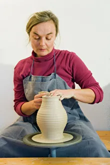 Ceramic artist working in her workshop with a potters wheel, turning a vase, Geisenhausen, Bavaria, Germany, Europe Ceramic artist working in her workshop with a potters wheel, turning a vase, Geisenhausen, Bavaria, Germany, Europe