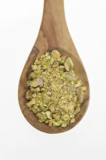 Chopped Pistachio (Pistacia vera) nuts on an olive wood spoon Chopped Pistachio (Pistacia vera) nuts on an olive wood spoon