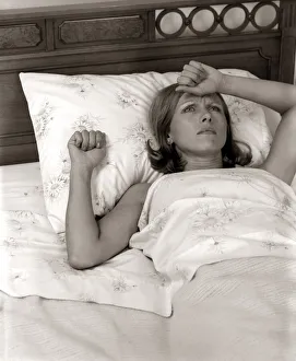 Close-Up Woman Lying In Bed With Pained Expression Holding Hand To Forehead Indoor Close-Up Woman Lying In Bed With Pained Expression Holding Hand To Forehead Indoor
