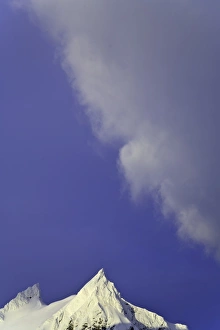 Clouds soaring in blue sky above snowy mountains Clouds soaring in blue sky above snowy mountains