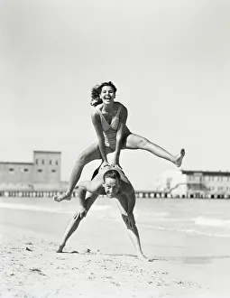 Collections/retrofile/couple playing leapfrog beach woman jumping man Collections/retrofile/couple playing leapfrog beach woman jumping man