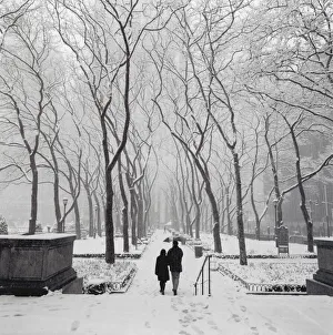 Couple walking in snow-covered park, New York City Couple walking in snow-covered park, New York City