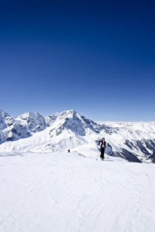 Cross-country skier ascending Hintere Schoentaufspitze Mountain, Solda, overlooking Ortler and Zebru Mountains Cross-country skier ascending Hintere Schoentaufspitze Mountain, Solda, overlooking Ortler and Zebru Mountains