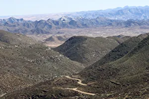 Dry valley with road in a Karoo landscape at Helskloof Pass, Richtersveld National Park Dry valley with road in a Karoo landscape at Helskloof Pass, Richtersveld National Park