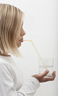 Eight-year-old girl drinking mineral water through a straw Eight-year-old girl drinking mineral water through a straw