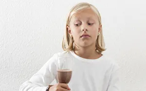 Eight-year-old girl viewing her drink skeptically Eight-year-old girl viewing her drink skeptically