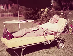 Elderly man relaxing on sun lounger in backyard. (Photo by H Elderly man relaxing on sun lounger in backyard. (Photo by H