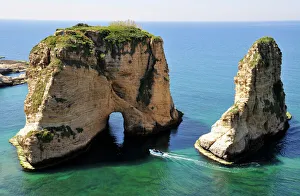 Excursion boat off the Pigeons Rock, Grotte aux Pigeons, limestone rocks eroded by wind Excursion boat off the Pigeons Rock, Grotte aux Pigeons, limestone rocks eroded by wind