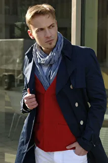 Fashion image, young man wearing a blue coat and a red sweater Fashion image, young man wearing a blue coat and a red sweater