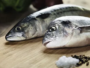 Two fish on a wood cutting board