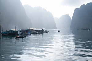 Floating Vietnamese fishing village with rocky coastline Floating Vietnamese fishing village with rocky coastline