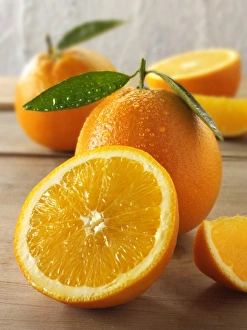Fresh oranges, whole and half with leaves Fresh oranges, whole and half with leaves