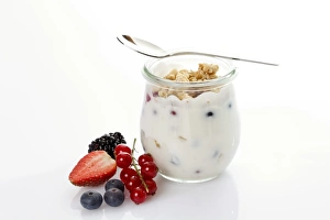 Glass and spoon with muesli, yoghurt, berries, red currants, blueberries, strawberry, blackberry Glass and spoon with muesli, yoghurt, berries, red currants, blueberries, strawberry, blackberry