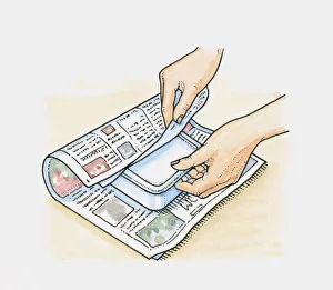Hands wrapping frozen food in newspapers to keep it cool Hands wrapping frozen food in newspapers to keep it cool