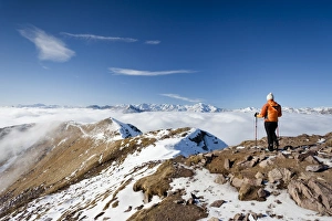 Hikers on Grosser Laugenspitze Mountain above Laugenalm alpine pasture, looking towards the Val d'Ultimo Mountains Hikers on Grosser Laugenspitze Mountain above Laugenalm alpine pasture, looking towards the Val d'Ultimo Mountains