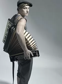 Accordions Collection: Man carrying an accordion, fashion shoot