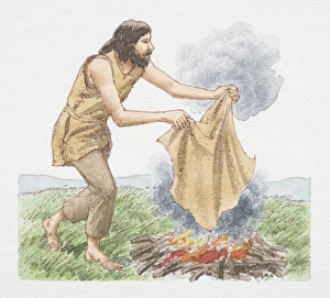 Man holding blanket over open fire to create smoke signals, side view Man holding blanket over open fire to create smoke signals, side view