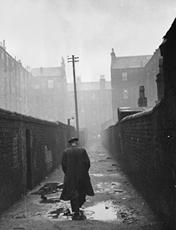 A man walking through a backstreet of the Gorbals area of Glasgow A man walking through a backstreet of the Gorbals area of Glasgow