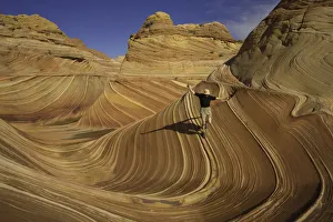 Mature man running down sandstone butte, arms raised Mature man running down sandstone butte, arms raised