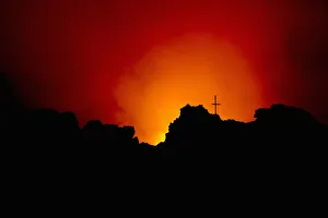 Memorial cross silhouetted on Mount Nyiragongo Volcano, Kibati, Virunga National Park Memorial cross silhouetted on Mount Nyiragongo Volcano, Kibati, Virunga National Park