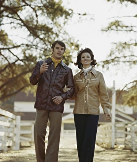Mid adult couple walking with arm in arm, smiling Mid adult couple walking with arm in arm, smiling