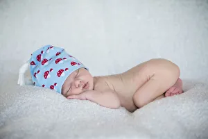 Newborn baby, 3 weeks, sleeping, wearing a hat Newborn baby, 3 weeks, sleeping, wearing a hat
