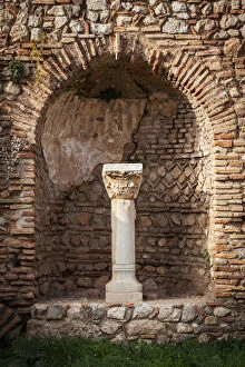 Niche in a stone wall with column and capitol