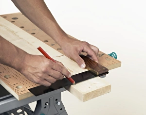 Person marking line on wood against square Person marking line on wood against square