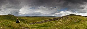 A Person Sits On A Hill With A View Of Hadrians Wall A Person Sits On A Hill With A View Of Hadrians Wall