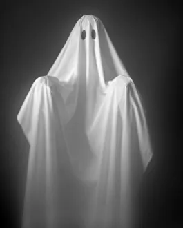 Person Wearing A Ghost Costume, Made Out Of A White Sheet With Two Holes In It Person Wearing A Ghost Costume, Made Out Of A White Sheet With Two Holes In It