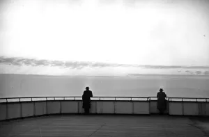 Prints of 1952: Two men lean on the rails on deck of the Queen Elizabeth as the liner comes to dock at Southampton. Original Publication: Picture Post - 6344 -The Queen Elizabeth Comes In - unpub Southampton Prints: 1952 QE2 Liner Print: Two Men on Deck at Southampton