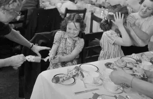 A family pulling a cracker print from 1953